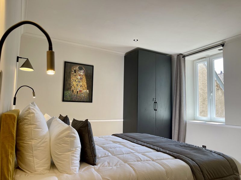 Chambre lit Queen size Dijon Suite Charlotte Alfred Suites